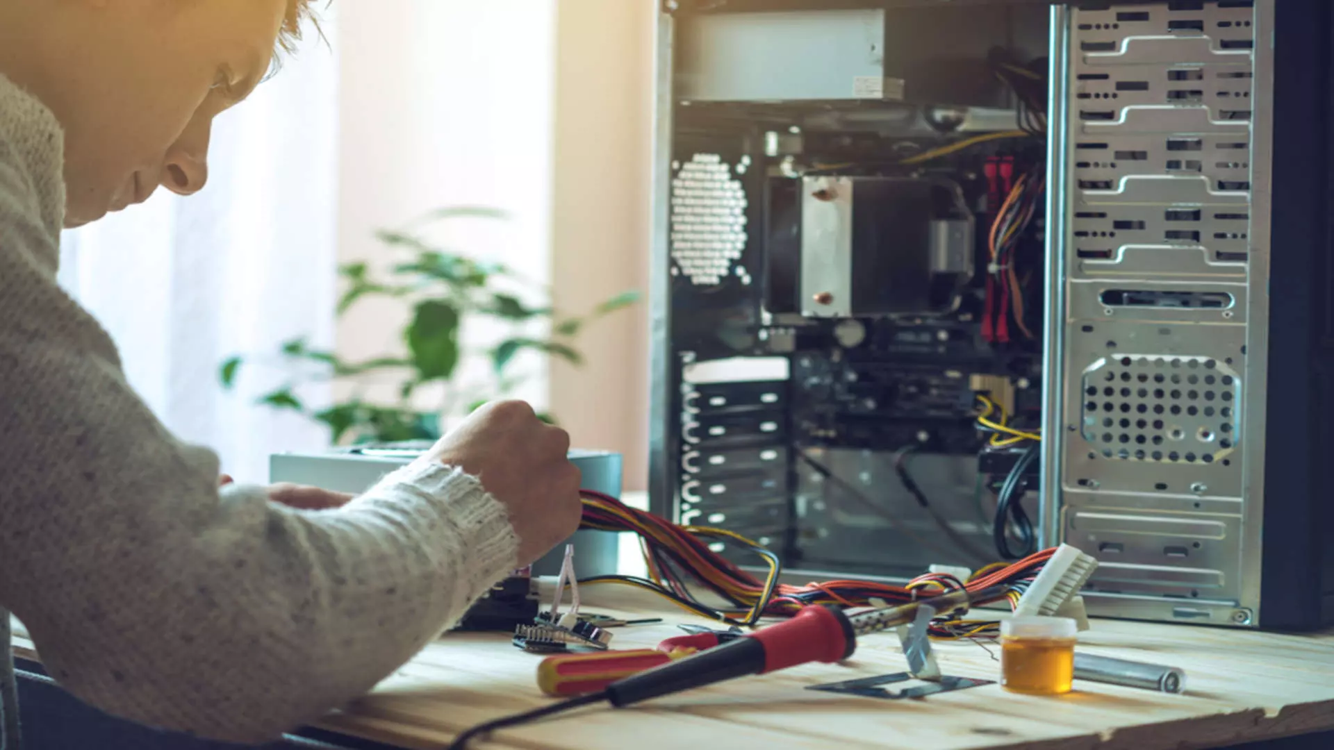 Technik naprawiający komputer stacjonarny Klientowi, który ma podpisaną umowę na obsługę IT Technik naprawiający komputer stacjonarny