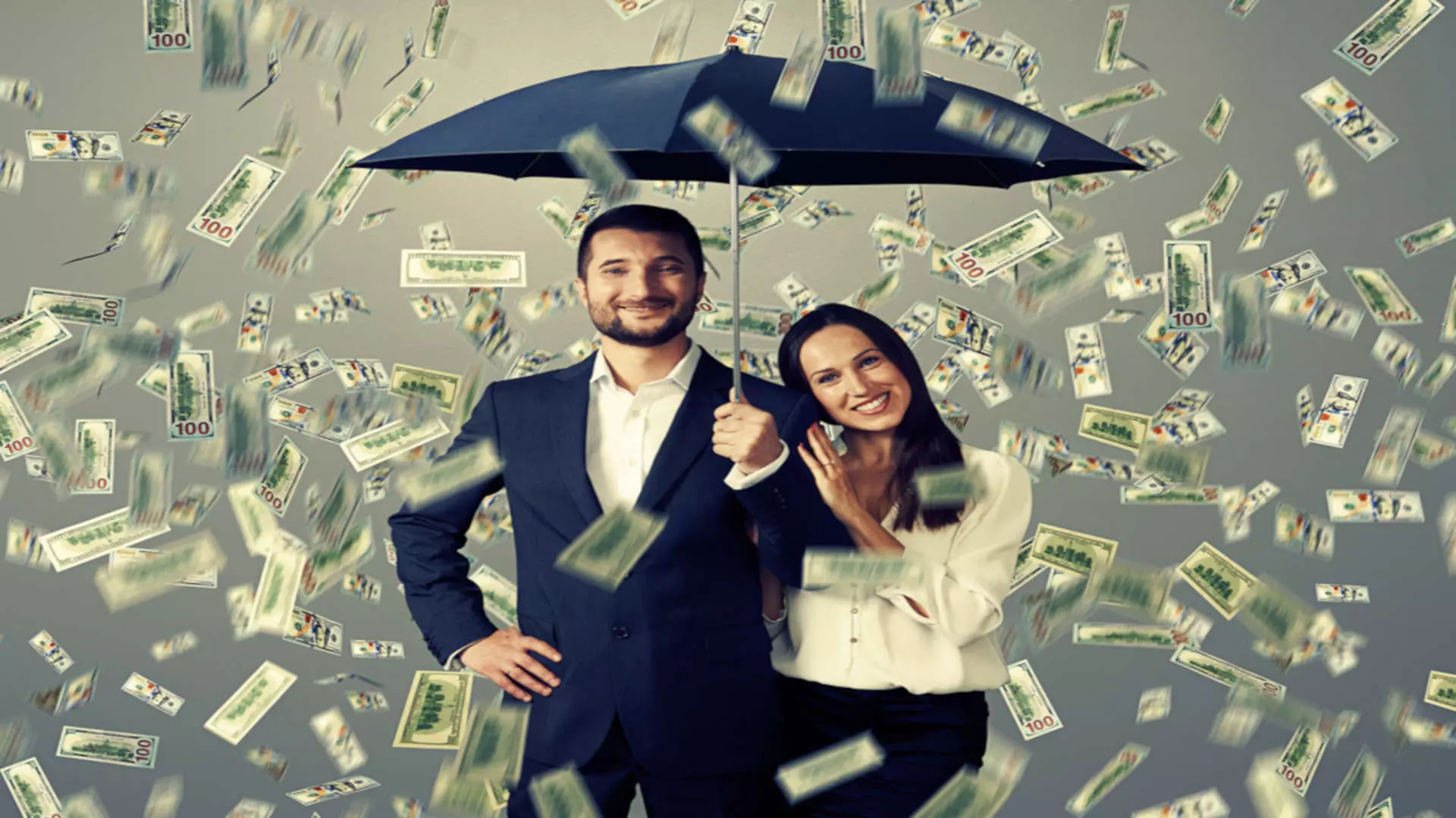 Para pod parasolem w deszczu pieniędzy